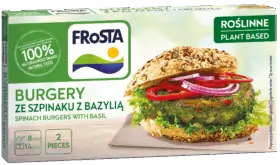 Egy doboz FRoSTA növényi alapú spenótburger bazsalikomos zsemlével, salátával, paradicsommal, hagymával; a csomagolás 100%-ban természetes ízt mutat.